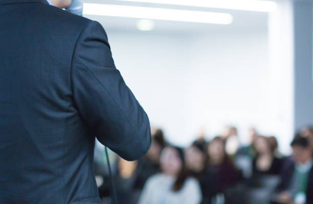 istock Meeting concept. Conference blur with business people training and learning. Coaching concept with blurred background. Speaker talking to audience in hall during seminar event. Lecture series speech. 1199440553