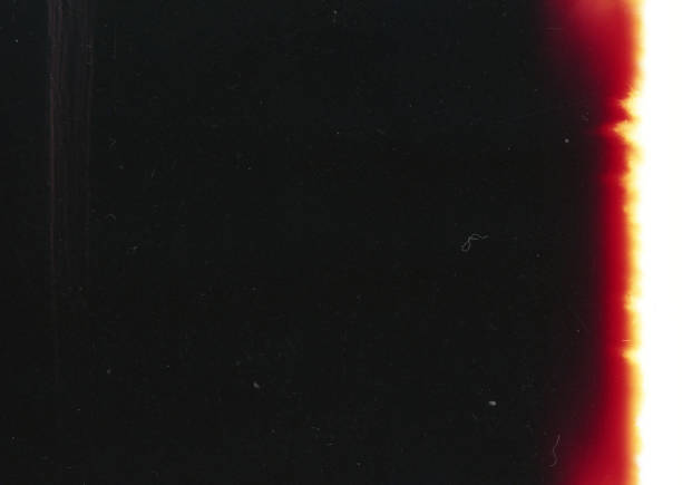 Old Light Leak Film Strip Grunge Texture Background A close-up scan of an old scratched 35mm color film with a beautiful red light leak strip grunge texture background. sun photos stock pictures, royalty-free photos & images