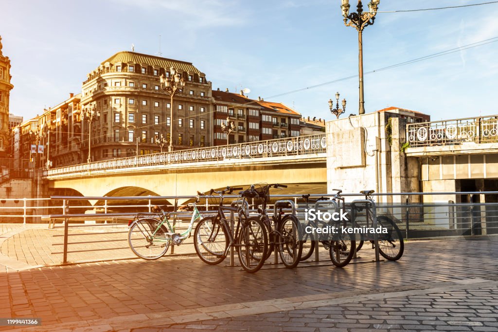 bicicletas estacionadas cerca del famoso puente del ayuntamiento en la ciudad de Bilbao. España - Foto de stock de Andar en bicicleta libre de derechos