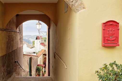 Calle de un pueblo toscano con paisaje y buzón de correo photo