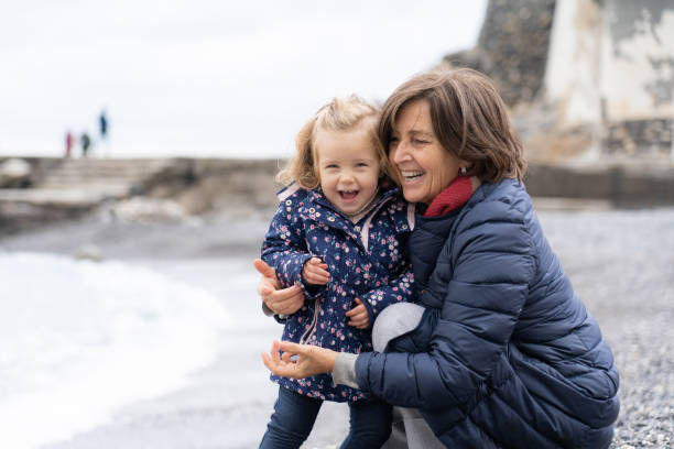 Granmother and granddaughter on the beach in winter stock photo