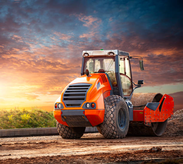 Road Roller at Construction Site Road Roller at Construction Site. Orange road roller and sunset background flattening stock pictures, royalty-free photos & images