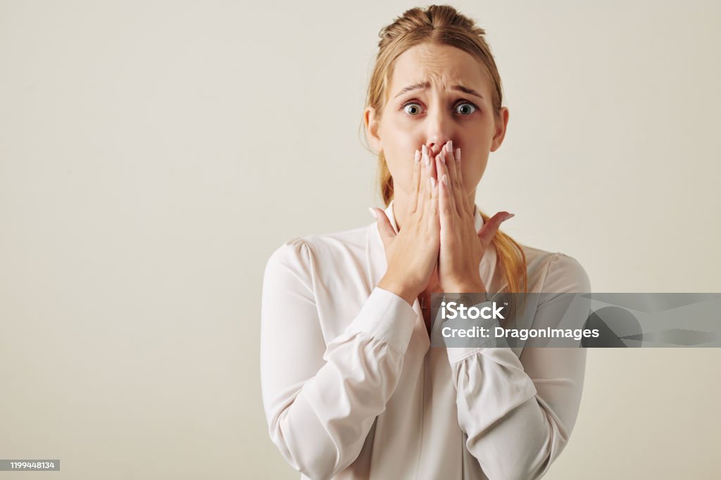 Caucasian Woman Shocked With Something Horizontal waist up studio portrait shot of Caucasian woman feeling shock looking at camera covering her mouth Women Stock Photo