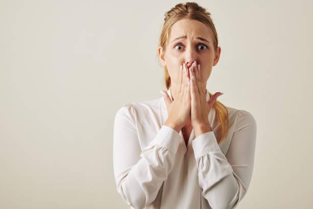 Caucasian Woman Shocked With Something Horizontal waist up studio portrait shot of Caucasian woman feeling shock looking at camera covering her mouth fear stock pictures, royalty-free photos & images