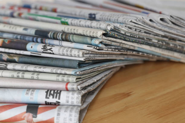 木製のテーブル上の新聞のクローズアップ、グローバルなコミュニケーションコンセプト - close up newspaper folded document ストックフォトと画像