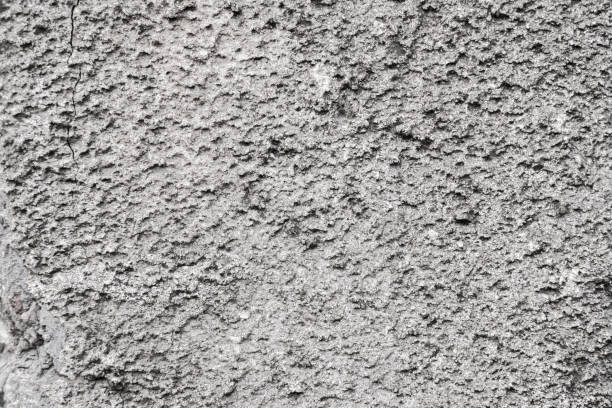 istock Cracked concrete grey wall covered with gray cement texture as background can be used in design. Dirty concrete texture with cracks and holes. 1199448394