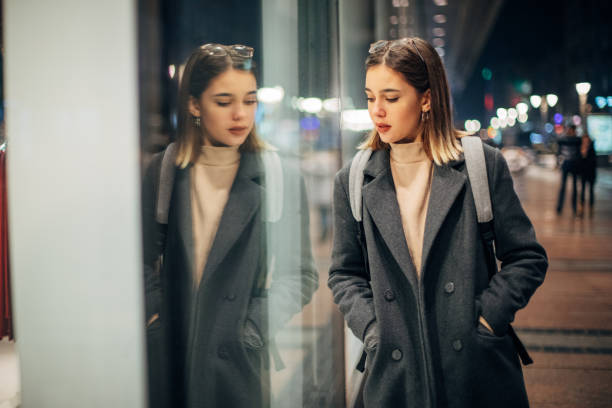 istock Woman looking to store window 1199449614