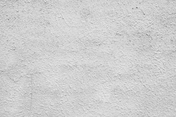 istock Cracked concrete grey wall covered with gray cement texture as background can be used in design. Dirty concrete texture with cracks and holes. 1199449790