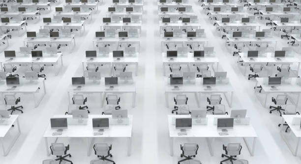 istock Many empty identical workplaces with computers in the interior of an office open space. Large bright office room in black and white without people. 3D rendering. 1199450058