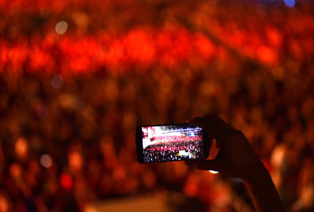 istock Hand holding smart phone and recording concert 1199454964