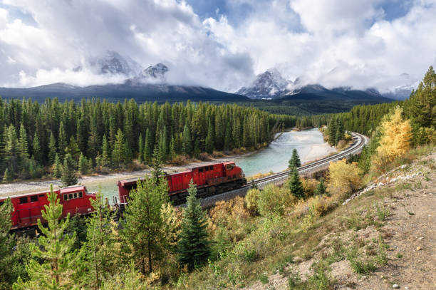 istock Red train long freight on railway passing in autumn valley and bow river at Morant's Curve 1199455145