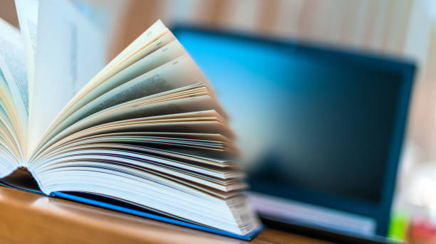 istock Open book lying on the table in the library 1199457562