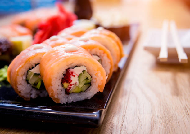 istock Sushi set. Rolls with salmon, eel and red caviar on a wooden plate. Restaurant. 1199460363