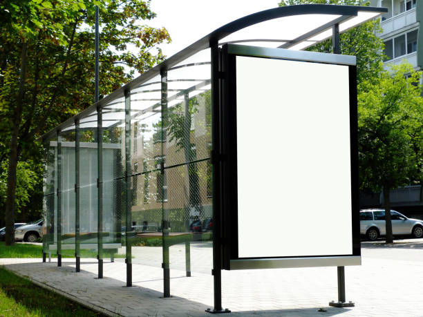 image collage of bus shelter at a bus stop of clear glass and aluminum frame image collage of bus shelter at a bus stop of transparent clear glass and aluminum frame structure in green street setting with trees in the background. milky white roof and white poster ad display glass and copy space. bus shelter stock pictures, royalty-free photos & images