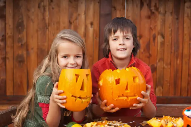 Kids showing their half ready jack-o-lanterns- preparing for Halloween