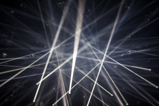 Laser show lights in front of black background