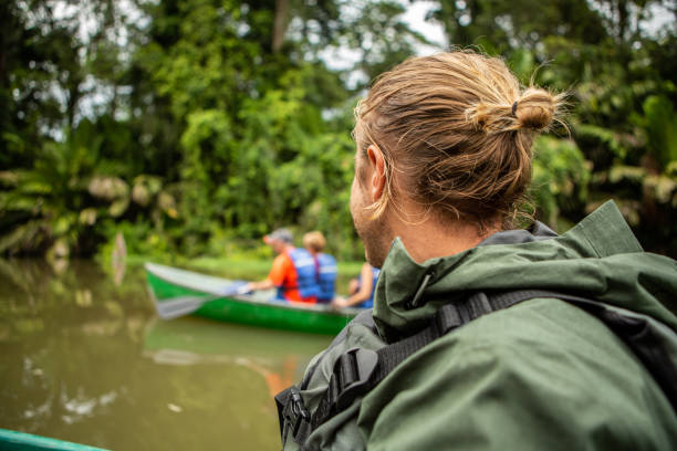 Tourists on canoe exploring Tortuguero Costa Rica rainforest Tortuguero Costa Rica rainforest tortuguero national park stock pictures, royalty-free photos & images