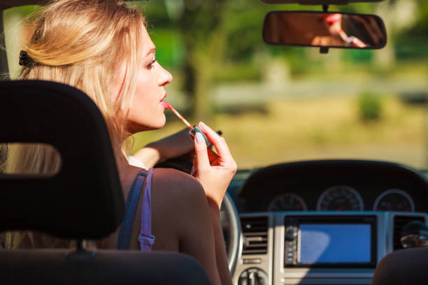 istock Girl apply make up while driving car. 1199466646