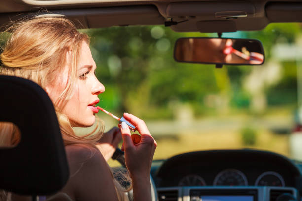 istock Girl apply make up while driving car. 1199466778