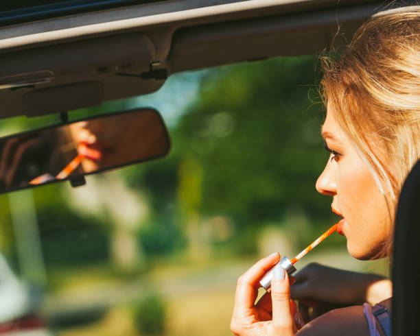 istock Girl apply make up while driving car. 1199466996
