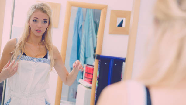 istock Woman fixing her hair in mirror 1199468309