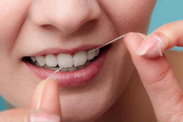istock Woman smiling with dental floss. 1199470358