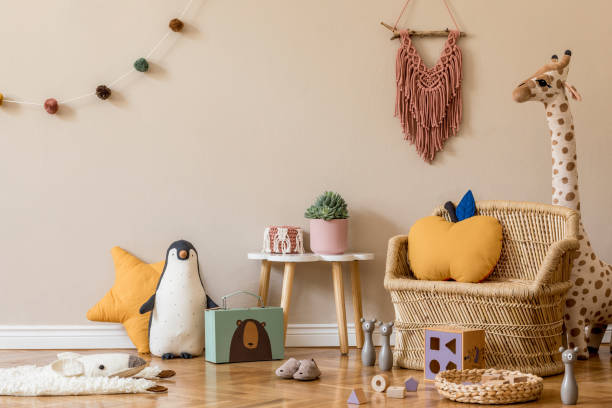 Stylish and modern scandinavian newborn baby interior with mock up photo or poster frame. Wooden toys and accessories. elegante interior escandinavo de la habitación para niños con juguetes naturales, decoración colgante, muebles de diseño, animales de felpa, osos de peluche y accesorios. paredes beige. diseño interior de la habitación para niños. plantilla.