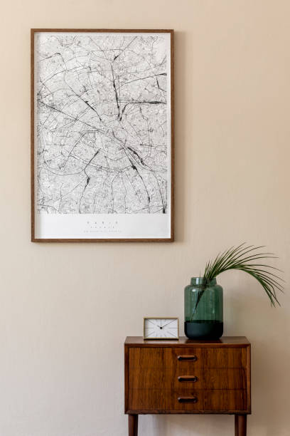 istock Modern scandinavian living room interior with mock up poster frame, design retro commode, tropical leaf in vase, gold clock and elegant accessories. Beige wall. Japandi. Template. Stylish home decor. 1199477354