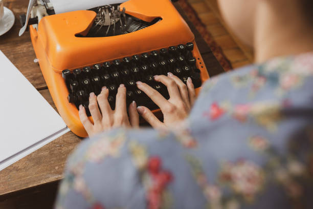 istock Woman writing on an old typewriter. 1199479145