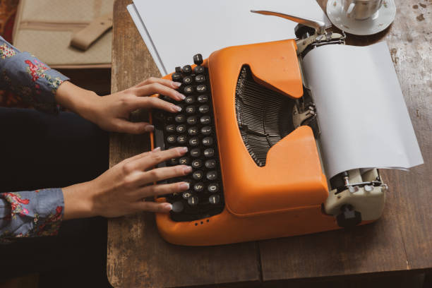 istock Woman writing on an old typewriter. 1199479784