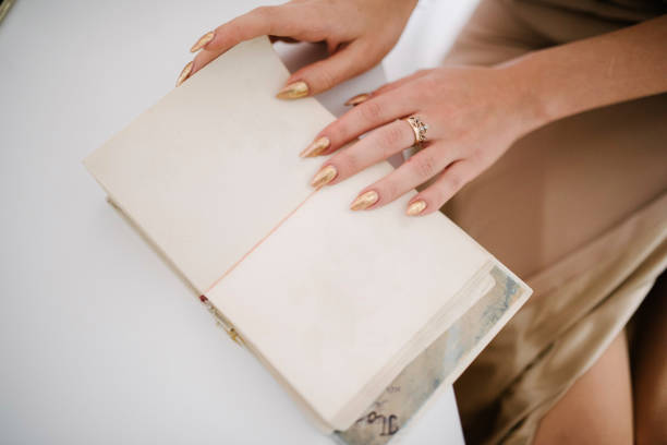 istock woman holds Open empty book in her hands. Open book with empty pages in woman's hands 1199480294