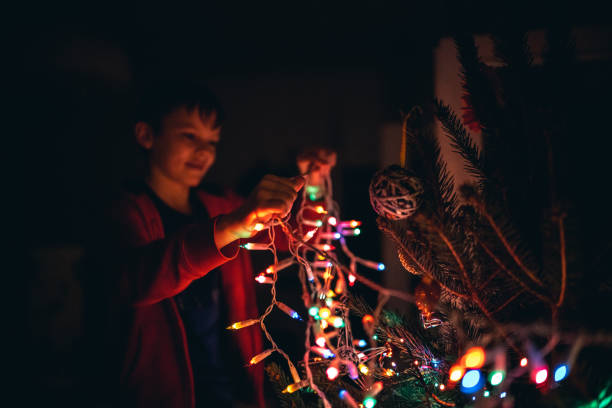 istock Boy Decorating Christmas tree at home 1199481743