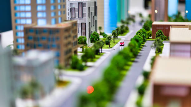urban avenue modern generic contemporary style miniature model of glass buildings and streets with tilt-shift focus technique - focus is on the red car in the middle of the street figurine stock pictures, royalty-free photos & images