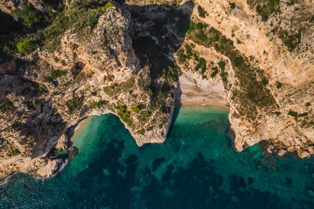 istock Aerial drone view on secret cozy beach sheltered between two rocky headlands Cala Moraig, Valencia community, Spain 1199484320