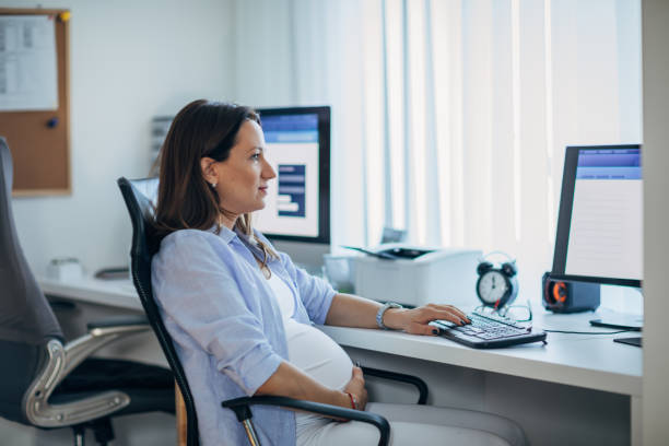 istock Pregnant woman working at the office 1199484326