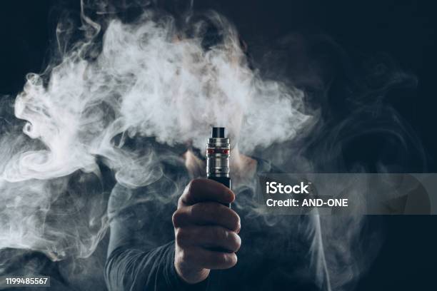 Vaping Eliquid From An Electronic Cigarette Stock Photo - Download Image Now - Electronic Cigarette, Pen, Addiction