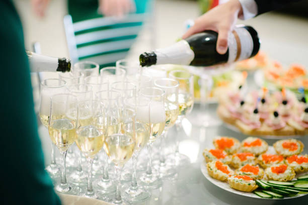 istock Man pours champagne into a glass from a bottle 1199485641