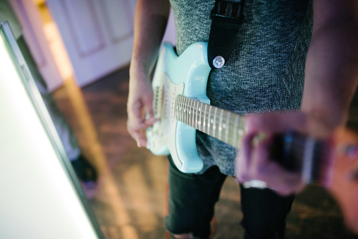 Man playing guitar indoors close up.Musician playing guitar close up