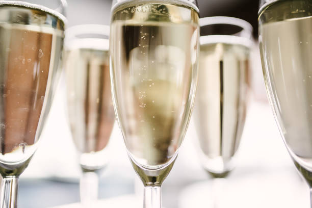 istock Man pours champagne into a glass from a bottle 1199488574