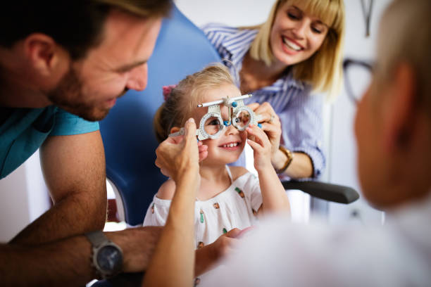 augenarzt überprüft die augensicht von kleinen niedlichen mädchen in der modernen klinik. - child glasses eyewear little girls stock-fotos und bilder