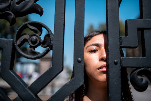 Headshot of the young women looking through the fence