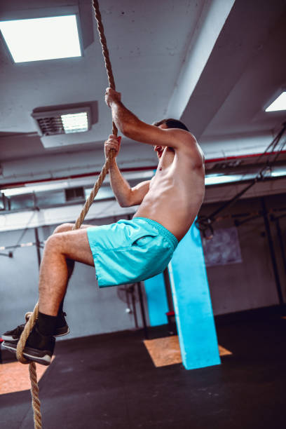istock Male Athlete Climbing Rope In Modern Gym 1199493204