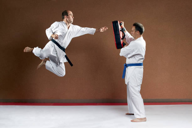 istock An athlete with a blue belt holds a simulator on which to strike another the athlete 1199493232