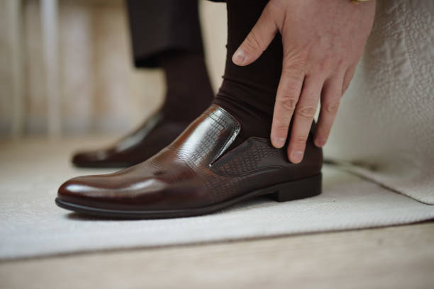 istock A man in a suit puts shoes on his feet. 1199493308