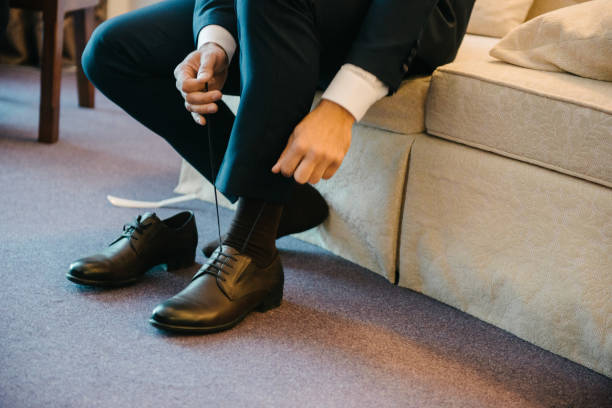 istock A man in a suit puts shoes on his feet. 1199493563