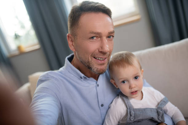 istock Mature father making selfie at home with his kid 1199495267