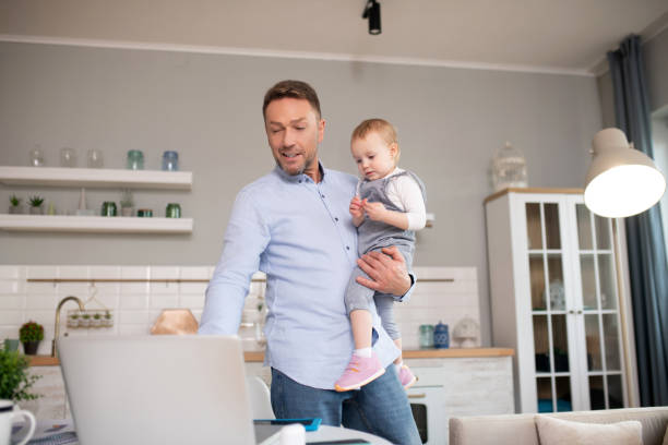 istock Man in a blue shirt standing and watching something on laptop 1199495950