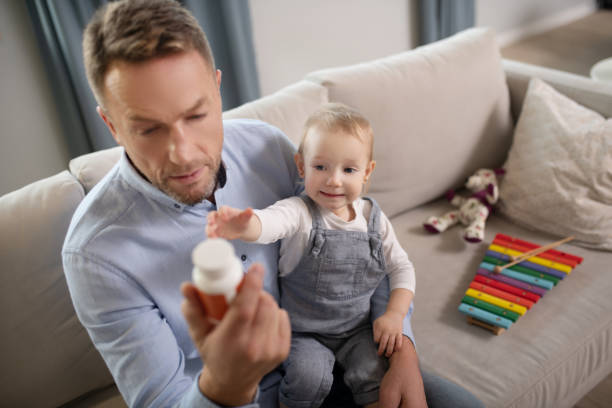istock Good-looking father looking attentive reading about vitamins 1199495990