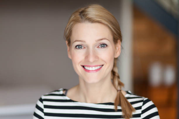 Close up Of A Smiling Caucasien blond woman in the living room stock photo