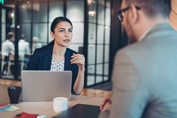 Businesswoman interviewing a man Business persons talking in the office talking two people business talk business stock pictures, royalty-free photos & images